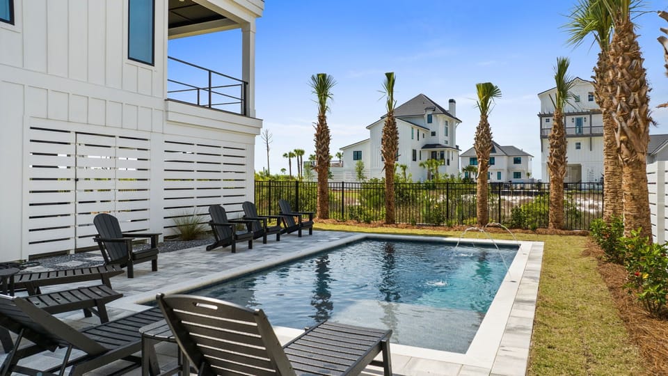 A private pool surrounded by lounge chairs and palm trees awaits your arrival at this coastal retreat. Unwind in your secluded outdoor space with plenty of seating and sunshine.