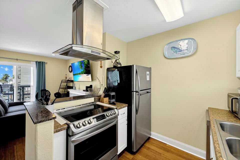 Your fully equipped kitchen features granite countertops, stainless appliances, and modern hood - perfect for creating memorable meals during your stay.