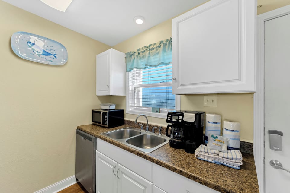 Your bright kitchenette awaits with modern appliances, granite counters, and coffee station ready for easy meal prep.