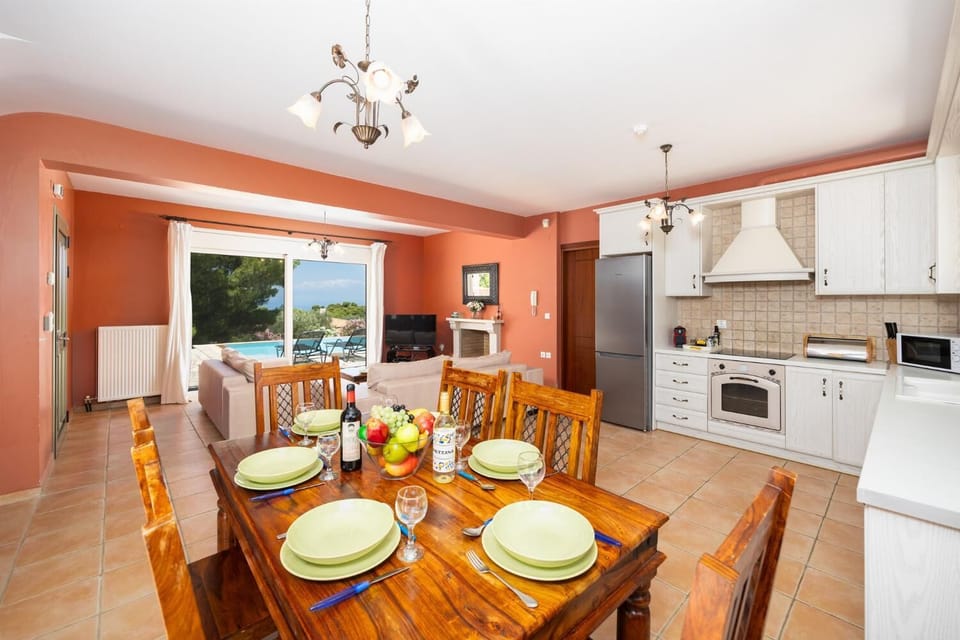 Open-plan living room with sofas, dining area, kitchen, ornamental fireplace, A/C, WiFi internet, and satellite TV