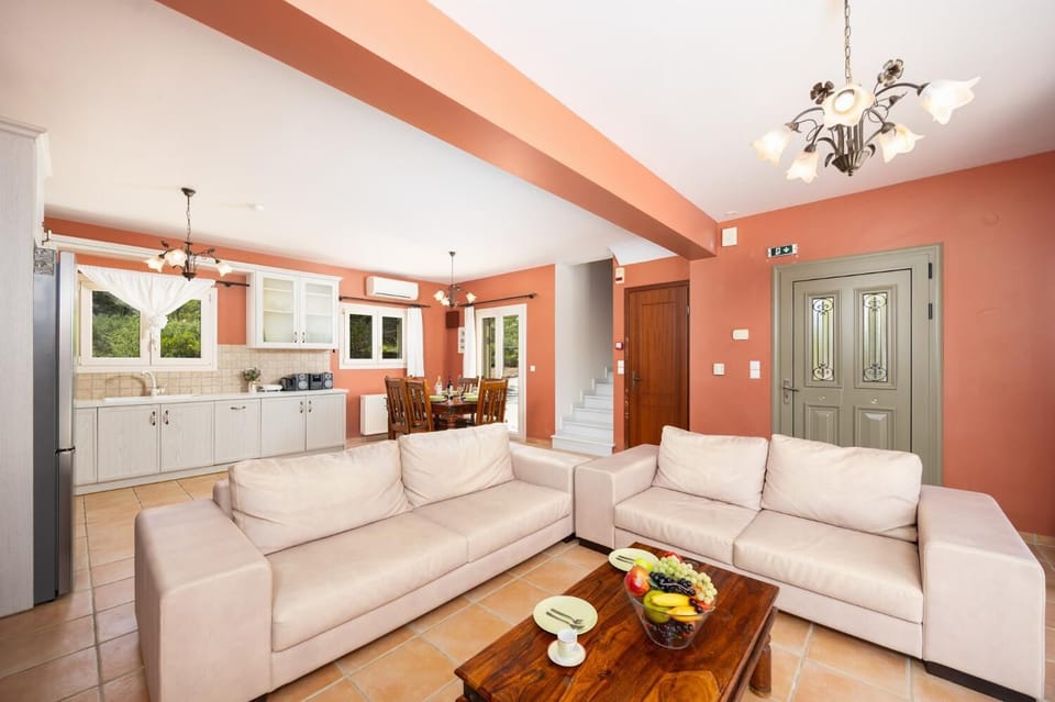 Open-plan living room with sofas, dining area, kitchen, ornamental fireplace, A/C, WiFi internet, and satellite TV