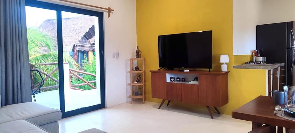 Living room with a view of the terrace, featuring a comfortable sofa and a Smart TV.