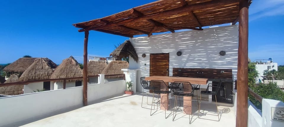 private rooftop with table and chairs and two lounge chairs