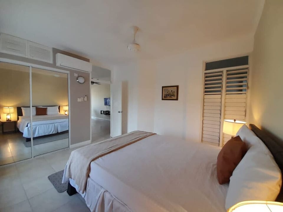 Bright bedroom w/ soft lighting, mirrored closet doors & a comfortable bed for restful nights