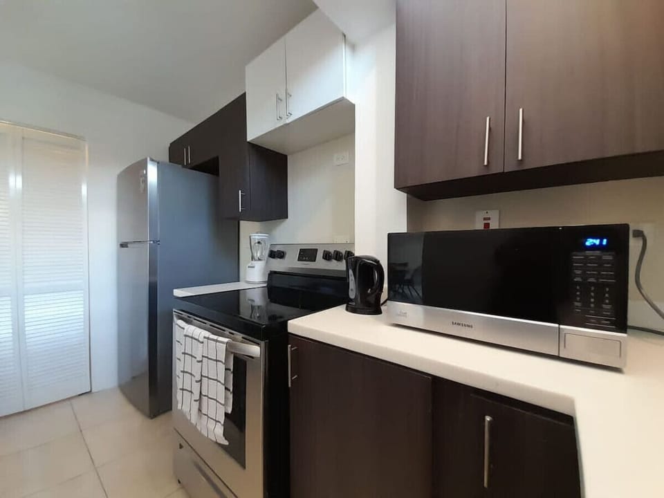Compact kitchen w/ stove, microwave & sleek cabinets ready for easy vacation meals