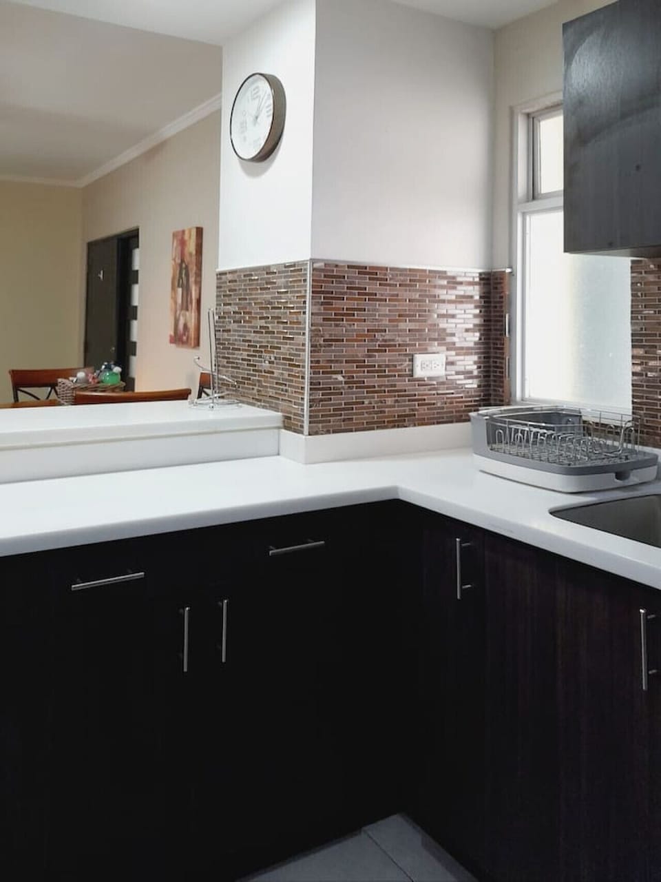 Corner kitchen counter w/ cooktop, modern cabinets & tiled backsplash accents