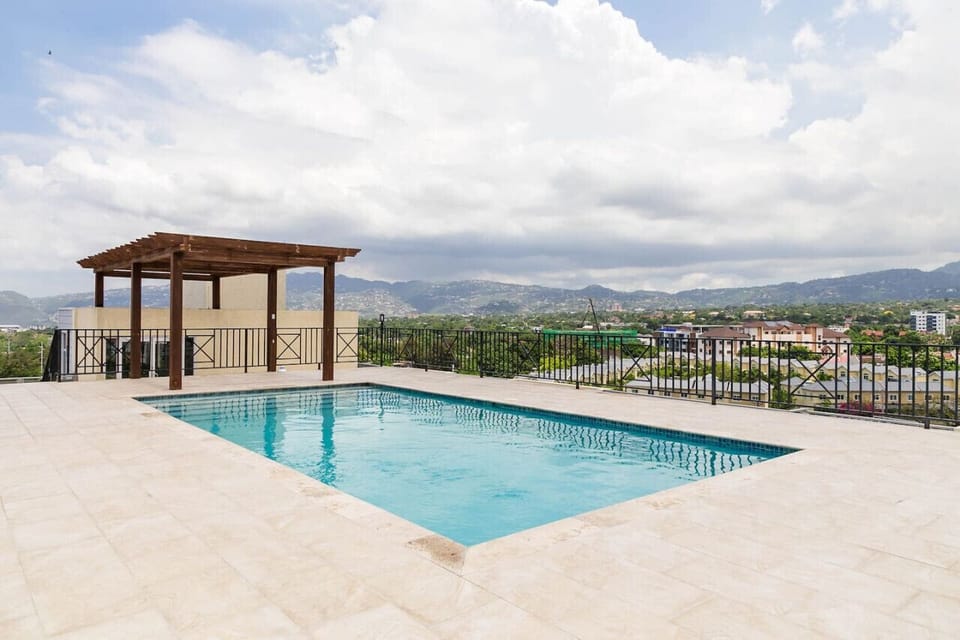 Spacious pool deck w/ pergola & open skyline views for relaxing swims anytime