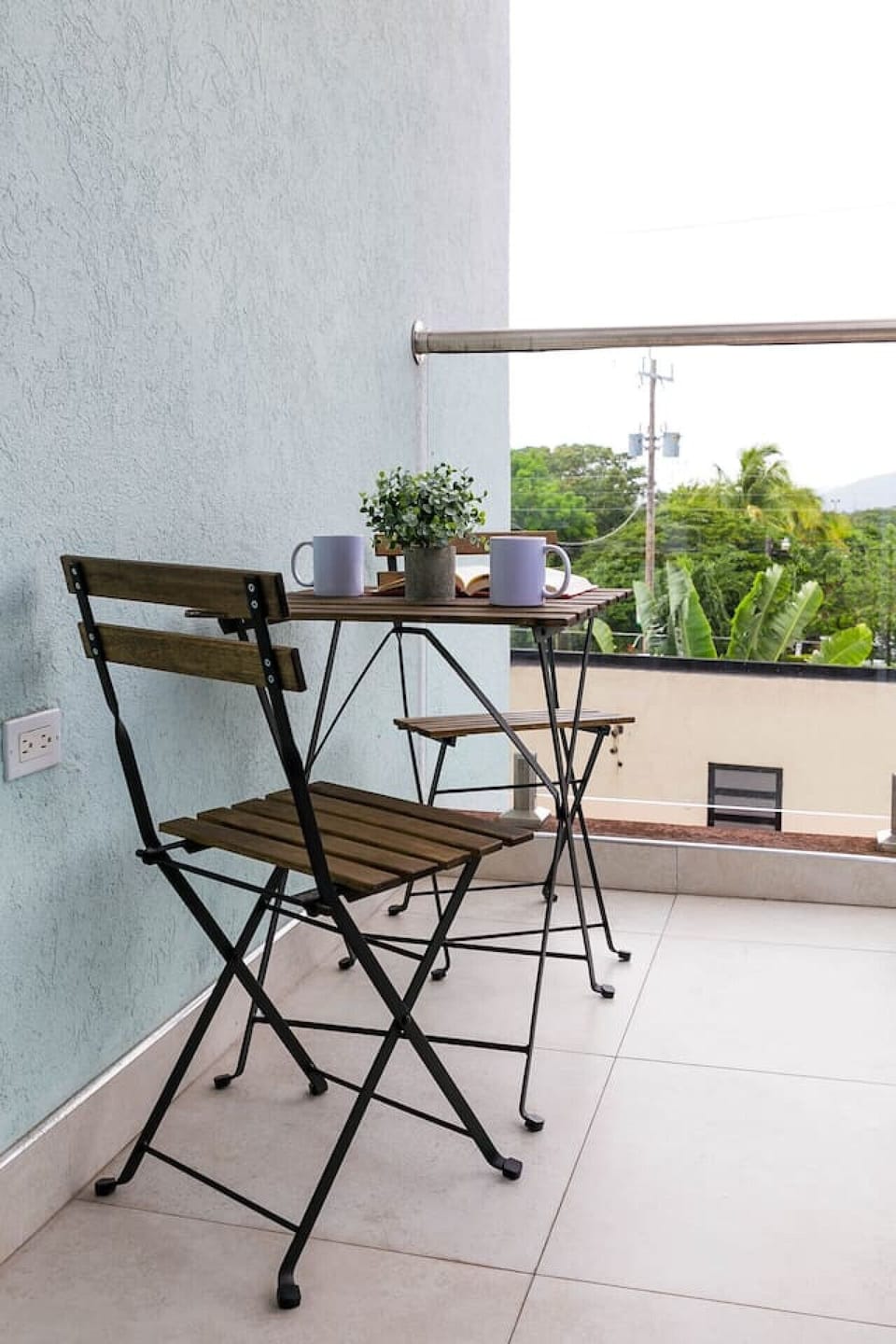 Charming balcony bistro set, a lovely spot to sip coffee while enjoying lush greenery