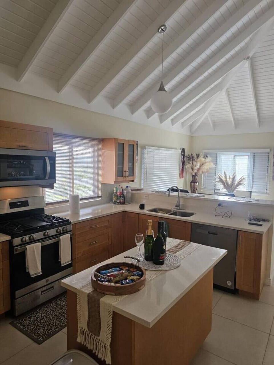 Bright kitchen w/ vaulted ceilings, large windows, island seating, and plenty of counter space for easy meal prep.