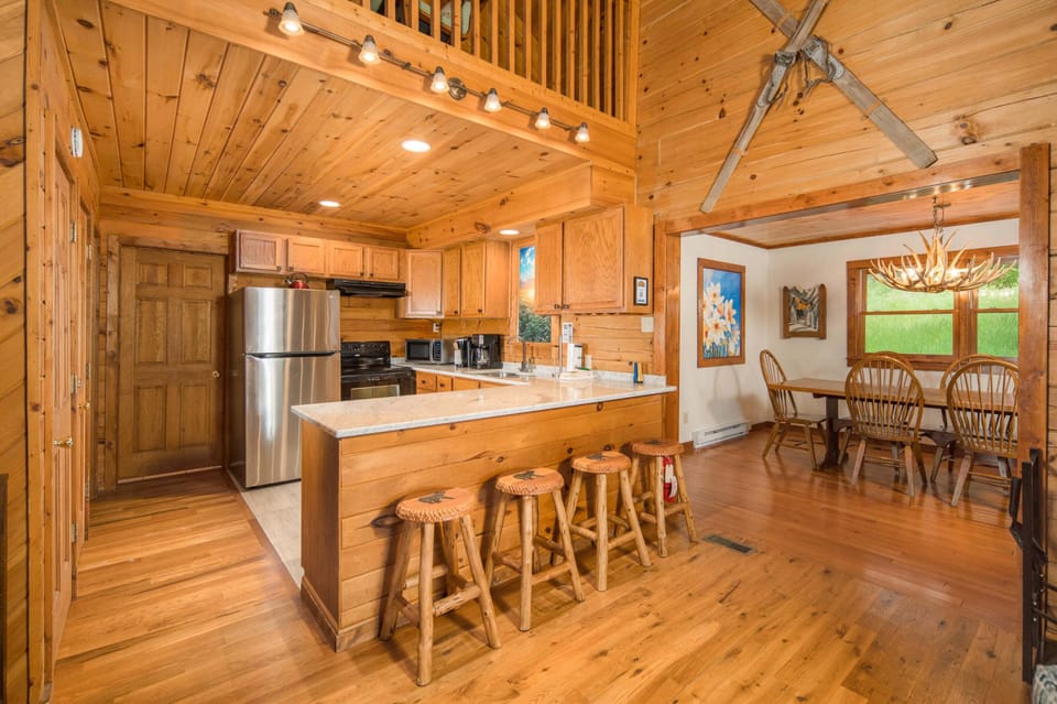 Fully equipped kitchen with bar seating for three and dining table seating for six
