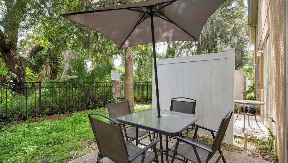 Outdoor patio with shaded seating surrounded by lush greenery