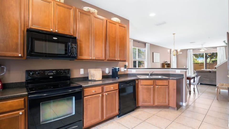 Open kitchen with modern appliances and ample counter space overlooking the dining and living areas.