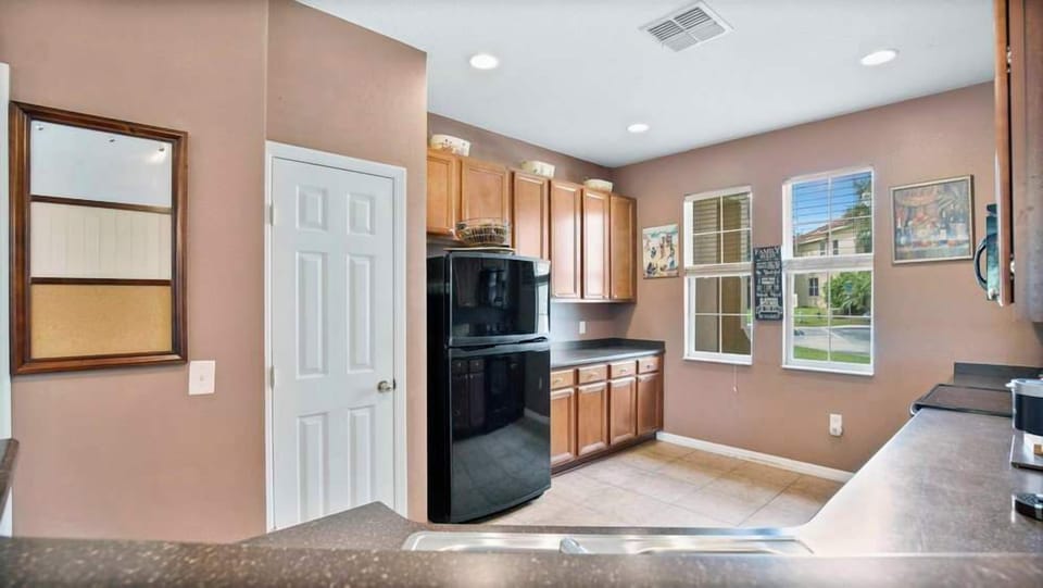 Bright kitchen with natural light and ample wooden cabinetry.