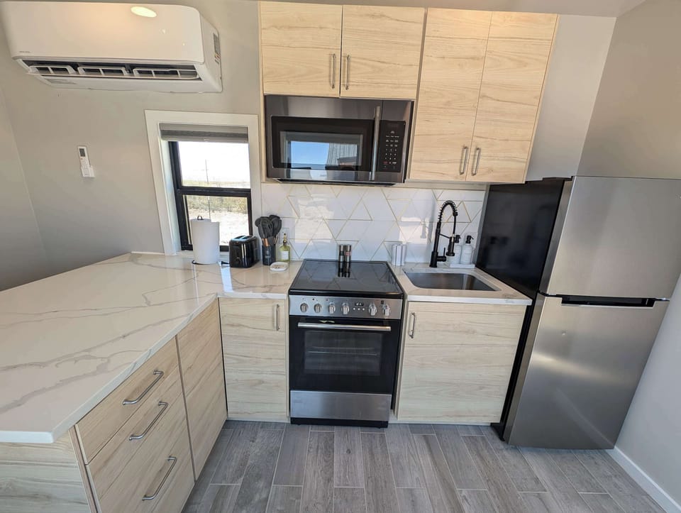 Kitchen with stove, oven, microwave and a full fridge and freezer