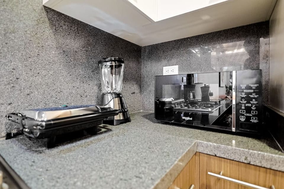 Fully equipped modern kitchen with stove, coffee maker, blender, and all essentials for your stay.