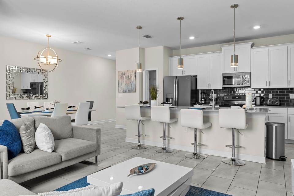 Relax in your spacious open-plan living area with modern kitchen, stylish seating, and bright contemporary design perfect for memorable gatherings.