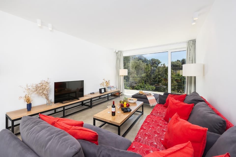 Open-plan living room with sofa, dining area, kitchen, A/C, WiFi internet, and satellite TV