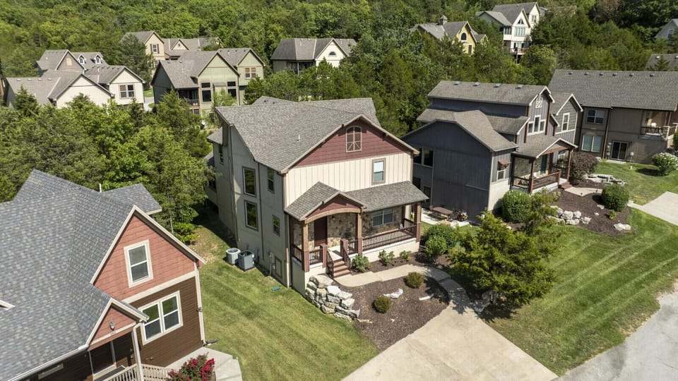 Charming two-story home surrounded by trees and neighboring cottages in a serene vacation community.