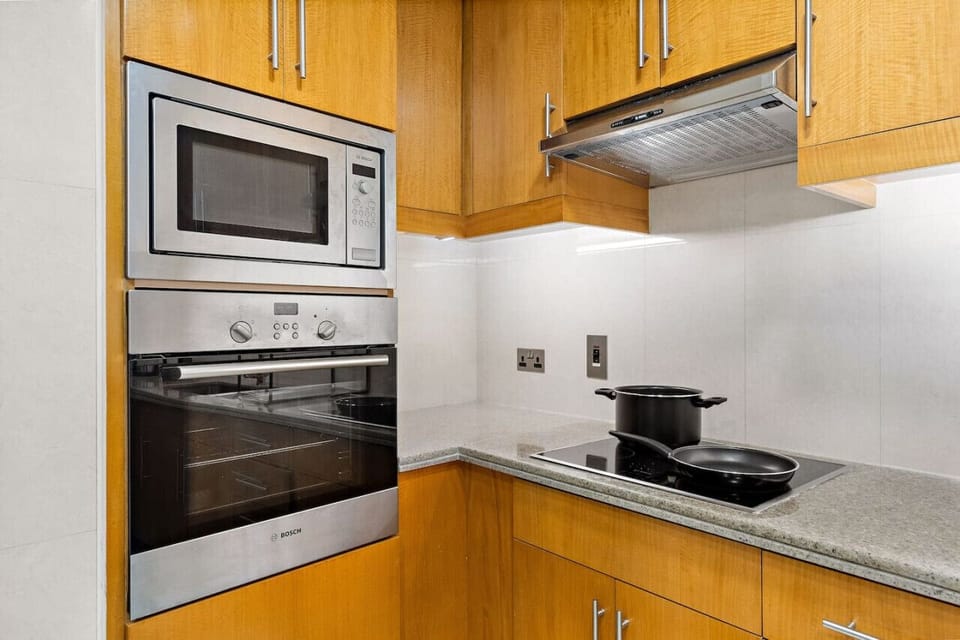 Kitchen appliances including a microwave, oven, and stovetop with pots.