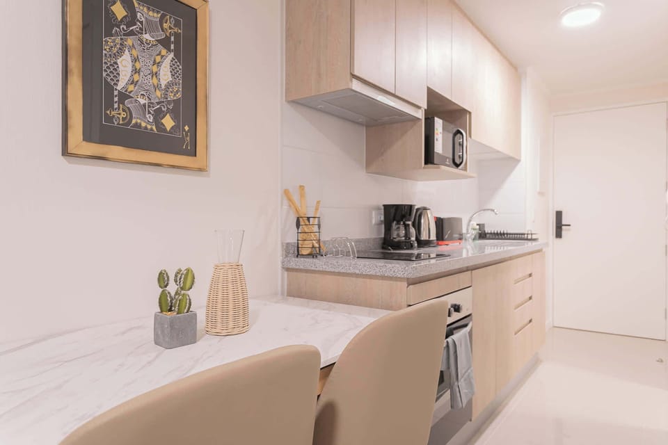 Modern kitchenette with sleek appliances and cozy dining space, perfect for a comfortable stay.