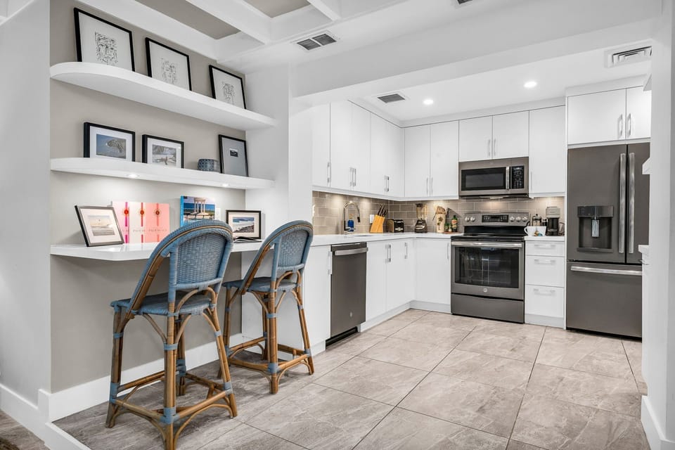 Fully equipped with Nespresso machine, blender, stainless steel appliances, service for 8, and 2 high bar stools for casual dining or remote work.
