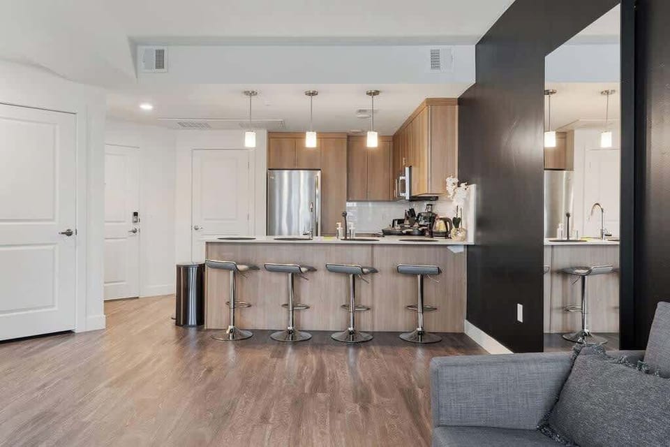 Your culinary haven – a modern kitchen with a bar counter, oven, toaster, and dishwasher for easy cleanup.