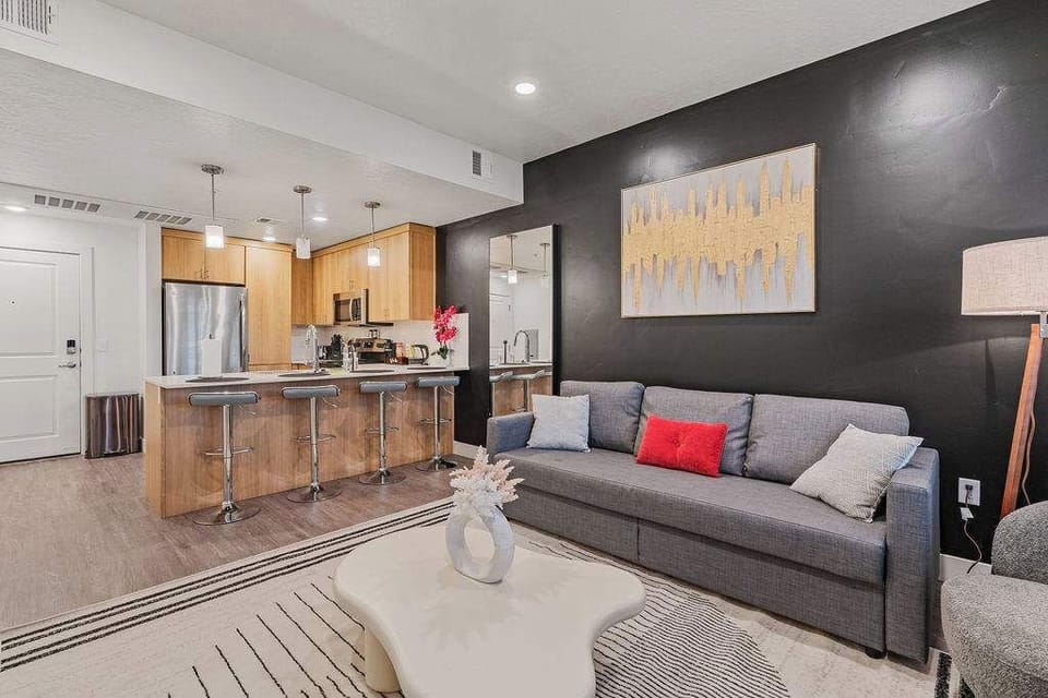 Unwind in our elegant living room, with comfortable sofas, a stylish center table, and a large TV.
