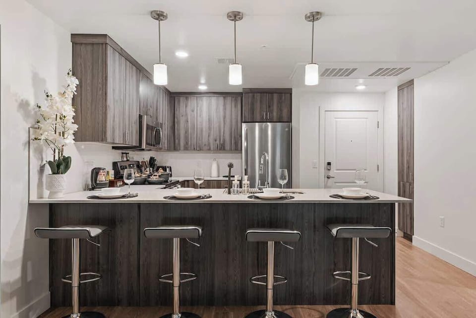 Spacious kitchen with an oven for cooking, a bar counter for dining, and a coffee maker for caffeine lovers.