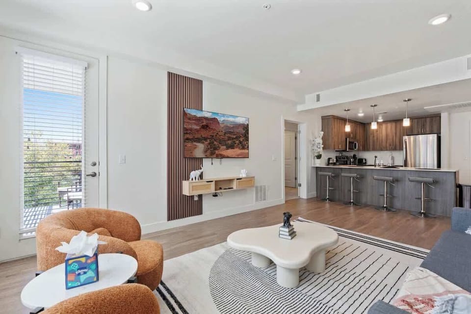 Unwind in our cozy living room, flooded with natural light from floor-to-ceiling windows.