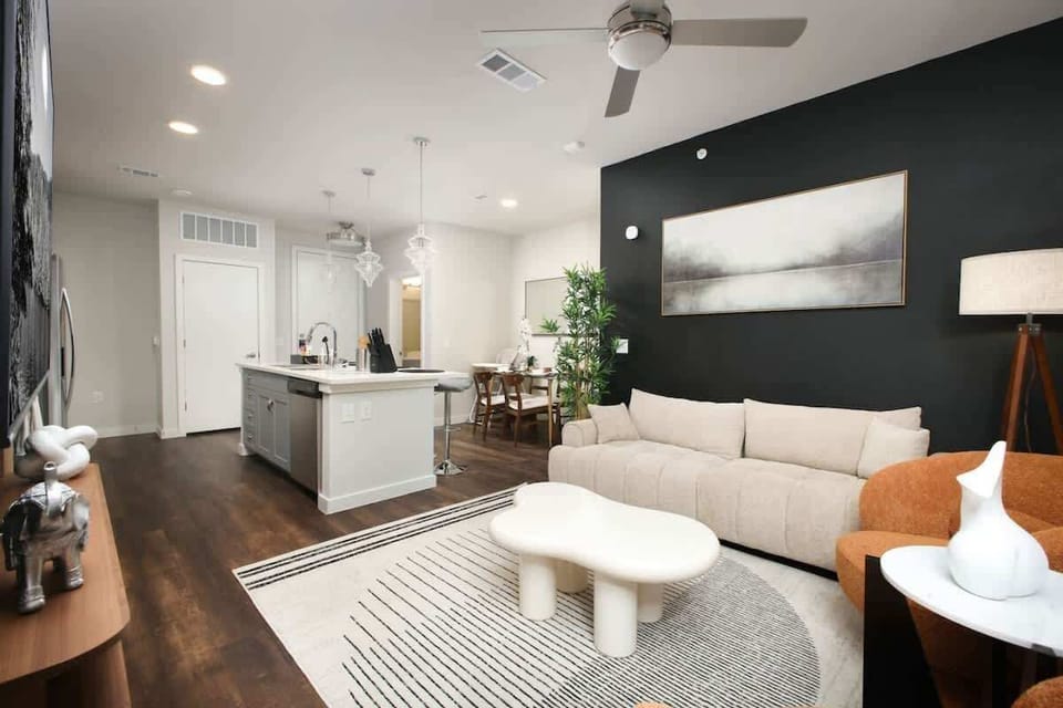 The perfect spot to relax – our living room boasts large windows, cozy sofas, and a hint of nature with a plant.
