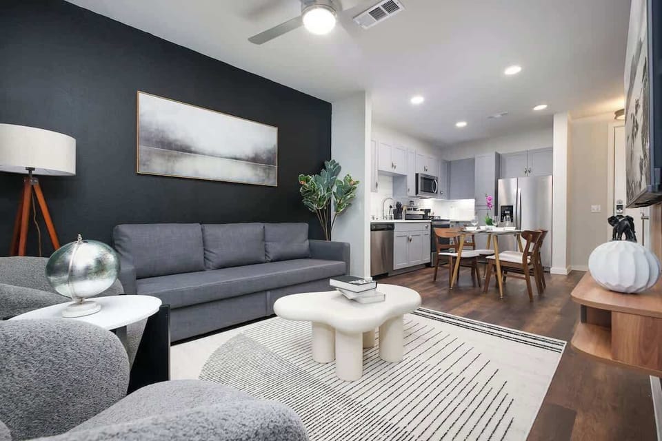 Settle into our cozy living room, where a comfy sofa, artistic decor, and a touch of green create a warm atmosphere.