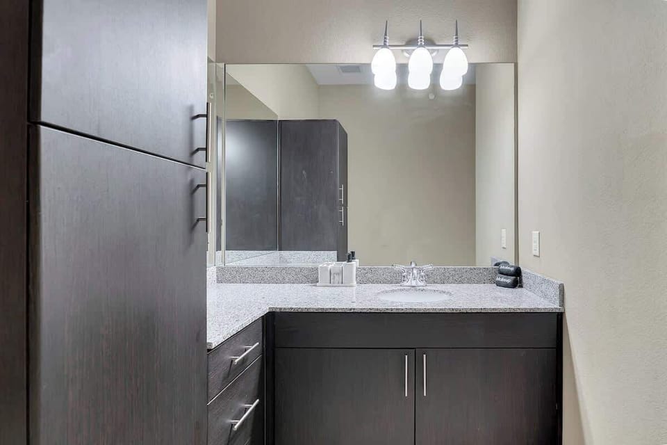 Pamper yourself in the spacious bathroom, complete with a sleek vanity, toilet, and relaxing bathtub.