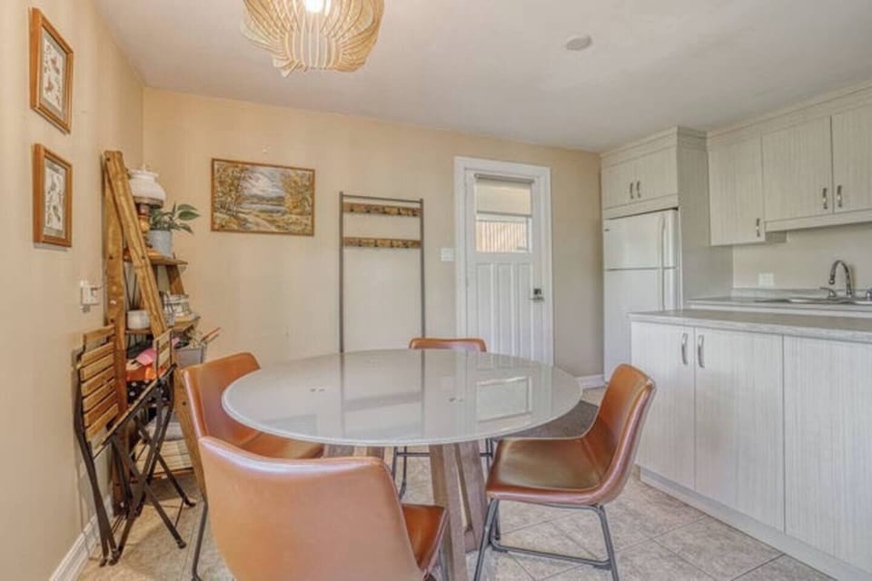 View from dining room to fully equipped kitchen with separate seating showing main cottage exterior door