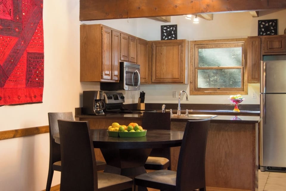 Your fully equipped kitchen features rich wood cabinetry, modern appliances, and a cozy dining nook—perfect for whipping up meals and enjoying intimate dinners together.