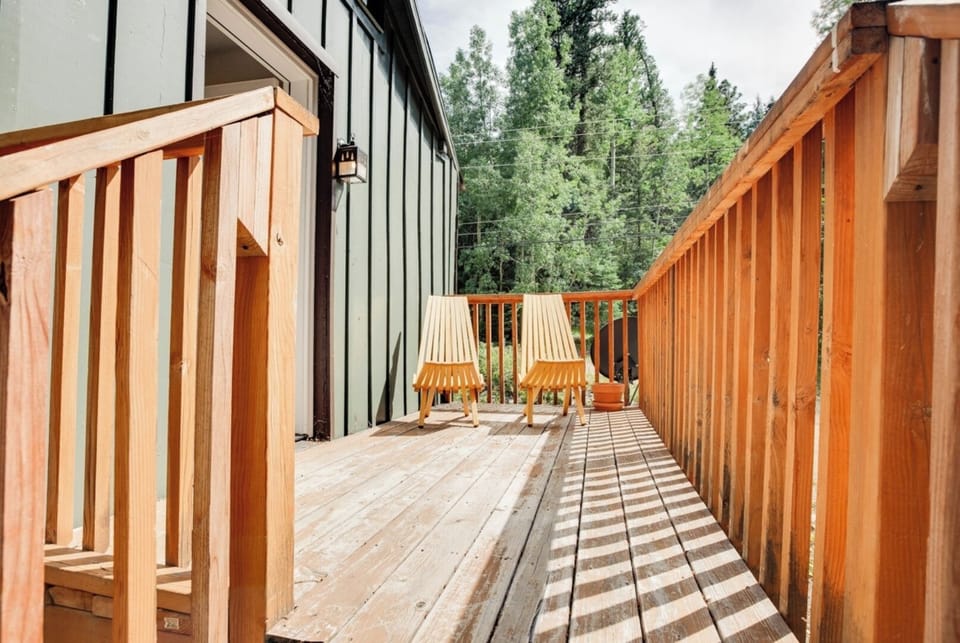Step onto your private deck where sunlight filters through towering pines, creating a peaceful retreat. Settle into the inviting chairs with a morning coffee or evening glass of wine, surrounded by the beauty of nature.