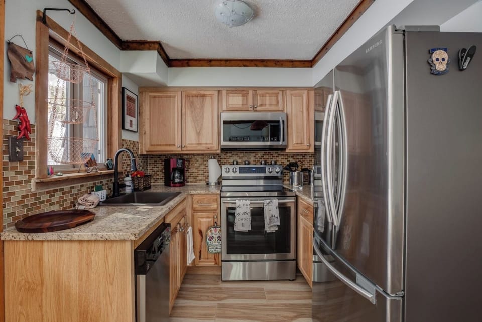 Your fully equipped kitchen welcomes you with stainless steel appliances, ample counter space, and warm wood cabinetry—ready for preparing meals in comfort.