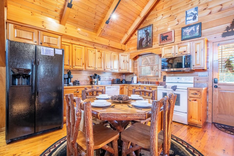 Your rustic log cabin kitchen combines charm with convenience, featuring full appliances and a handcrafted dining table perfect for memorable meals.