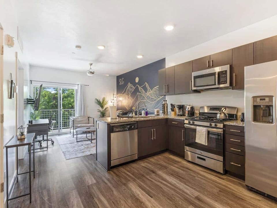 Open-concept kitchen & living space w/ granite counters & stainless steel appliances