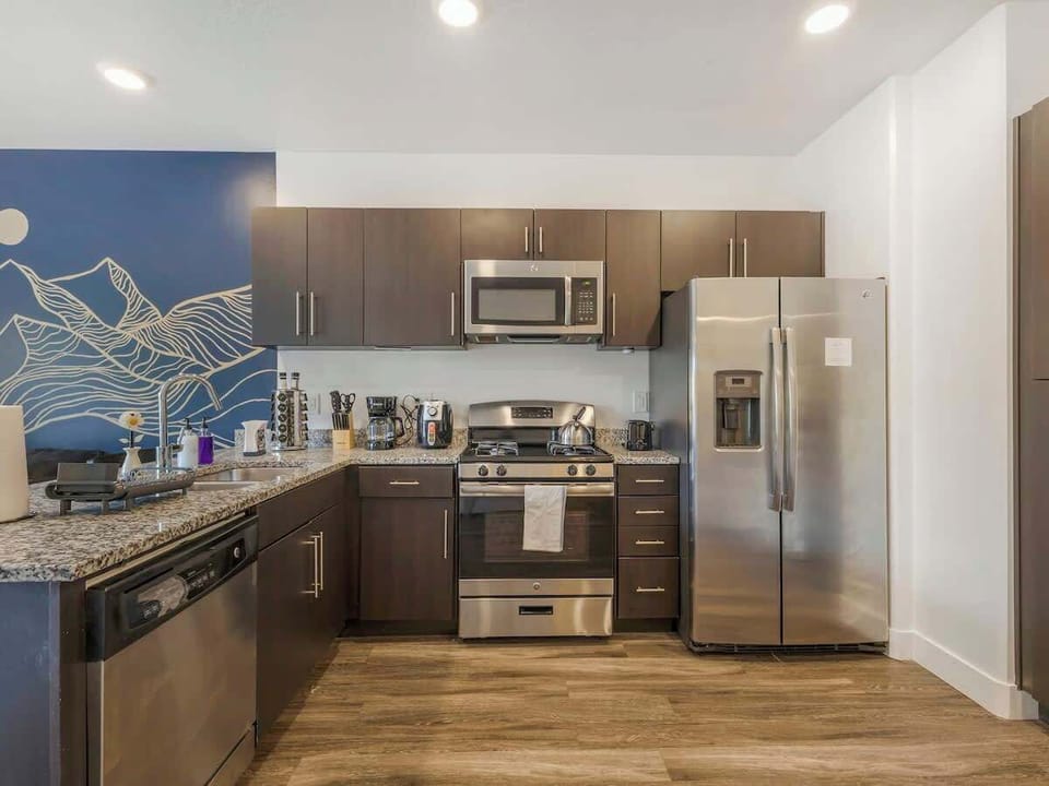 Sleek kitchen w/ stainless steel appliances, ample counter space, & clean finishes