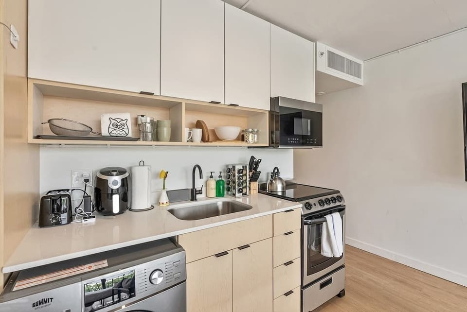 Sleek kitchenette w/ stove, microwave, sink & coffee setup for easy at-home meals