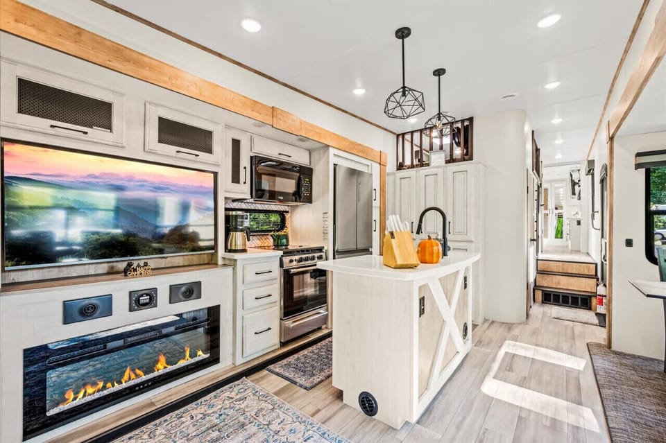 Living area view featuring a large flatscreen TV, Electric Fireplace, and Fully Stocked Kitchen