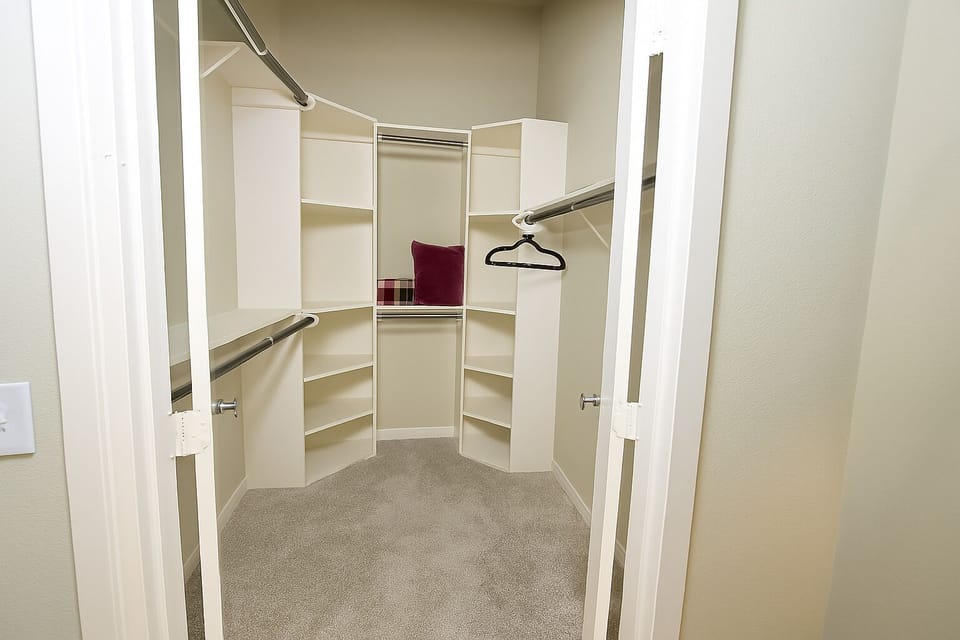 Organized walk-in closet with bright shelves and ample storage.