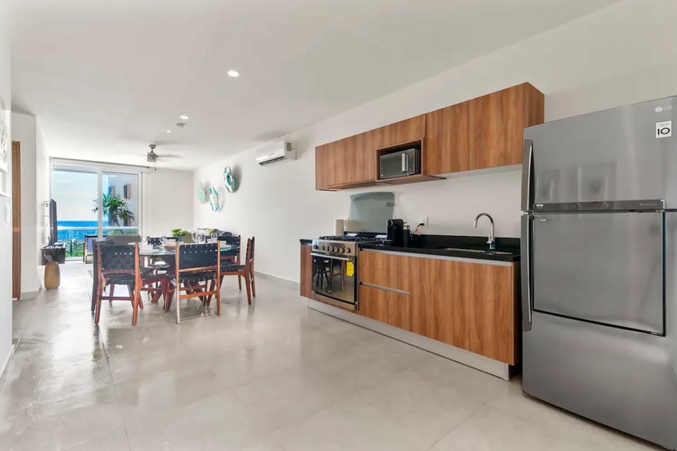 Fully stocked kitchen with coffee machine, blender, toaster, fridge, microwave, and 6-burner stove.