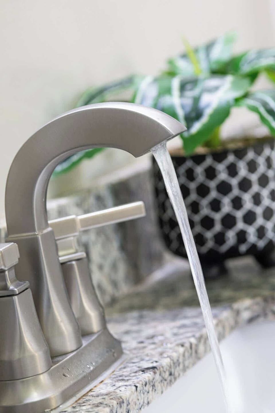 This elegant ensuite bathroom features a sleek double vanity, ample counter space, & abundant storage. Outfitted with modern amenities, it boasts a neutral color palette, creating a serene, spa-like atmosphere for a luxurious and relaxing experience