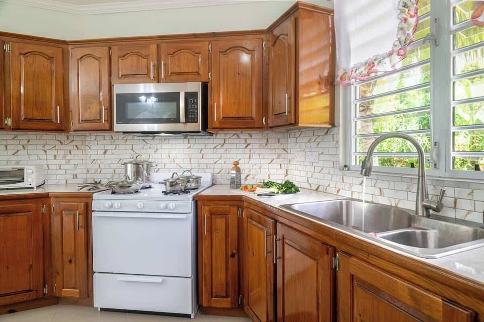 This spacious, fully-equipped kitchen boasts a large island, dedicated coffee station, and stunning mountain views through expansive glass windows. With a ceiling fan for comfort, it's the perfect haven for the family chef to create and entertain.
