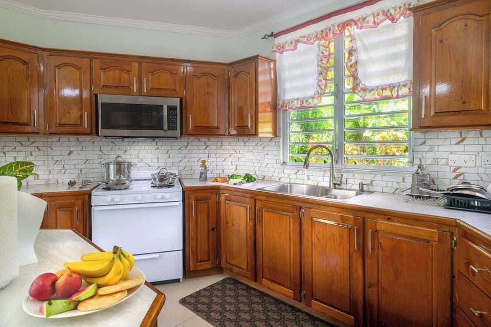 This spacious, fully-equipped kitchen boasts a large island, dedicated coffee station, and stunning mountain views through expansive glass windows. With a ceiling fan for comfort, it's the perfect haven for the family chef to create and entertain.