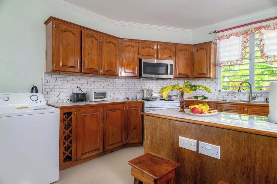 This spacious, fully-equipped kitchen boasts a large island, dedicated coffee station, and stunning mountain views through expansive glass windows. With a ceiling fan for comfort, it's the perfect haven for the family chef to create and entertain.