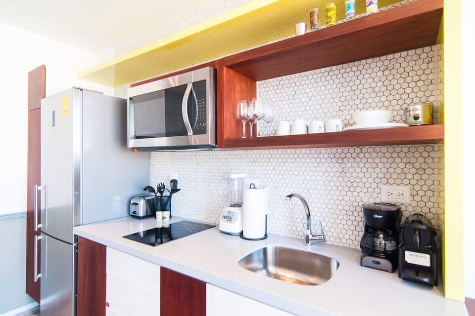 Efficient kitchen with 2-burner cooktop, full-sized fridge, and small appliances