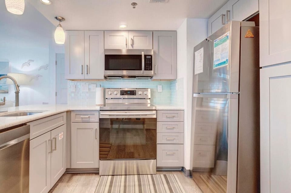 modern beach condo, featuring a completely remodeled kitchen equipped with top-of-the-line appliances and sleek finishes.