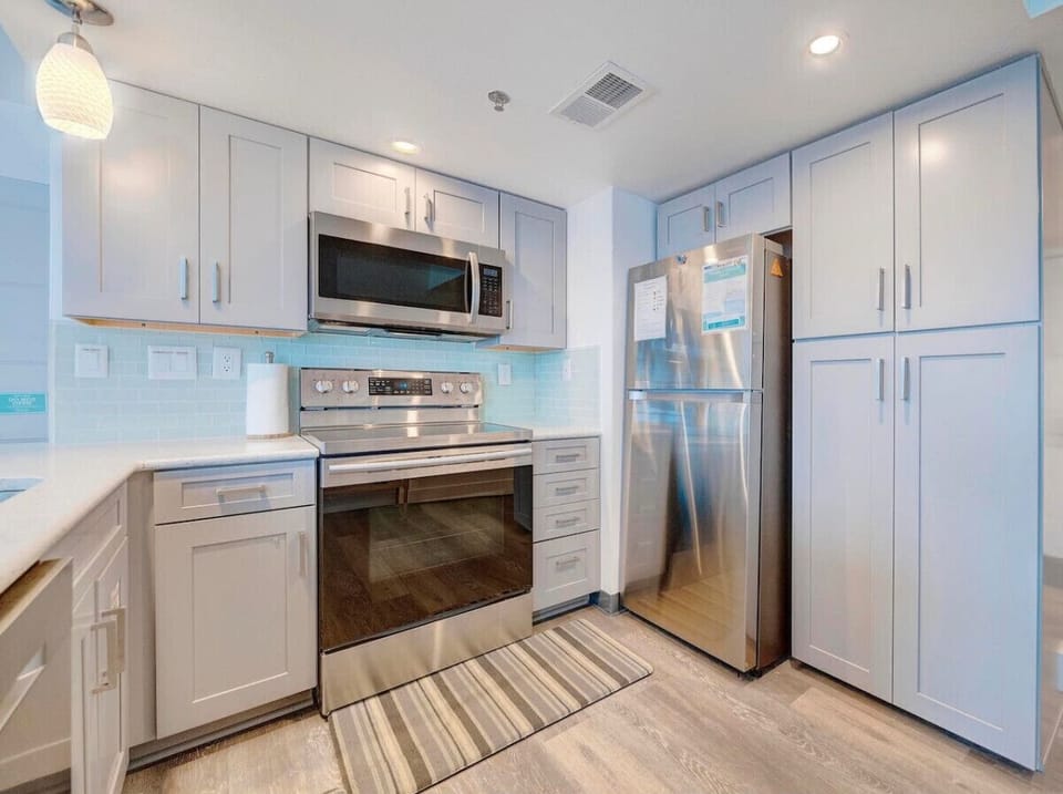 modern beach condo, featuring a completely remodeled kitchen equipped with top-of-the-line appliances and sleek finishes.